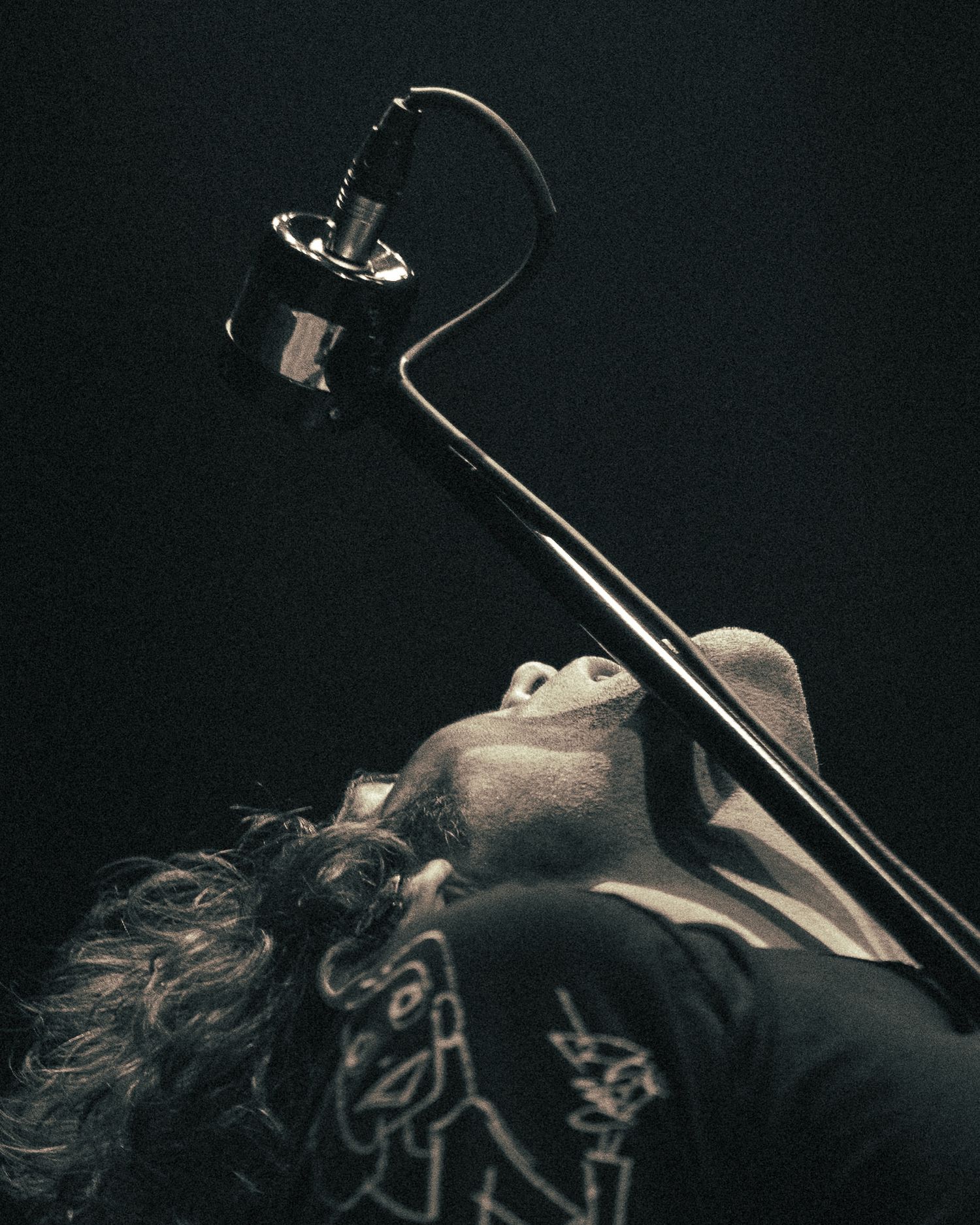 Black and white artistic shot of a musician performing with dramatic side lighting.