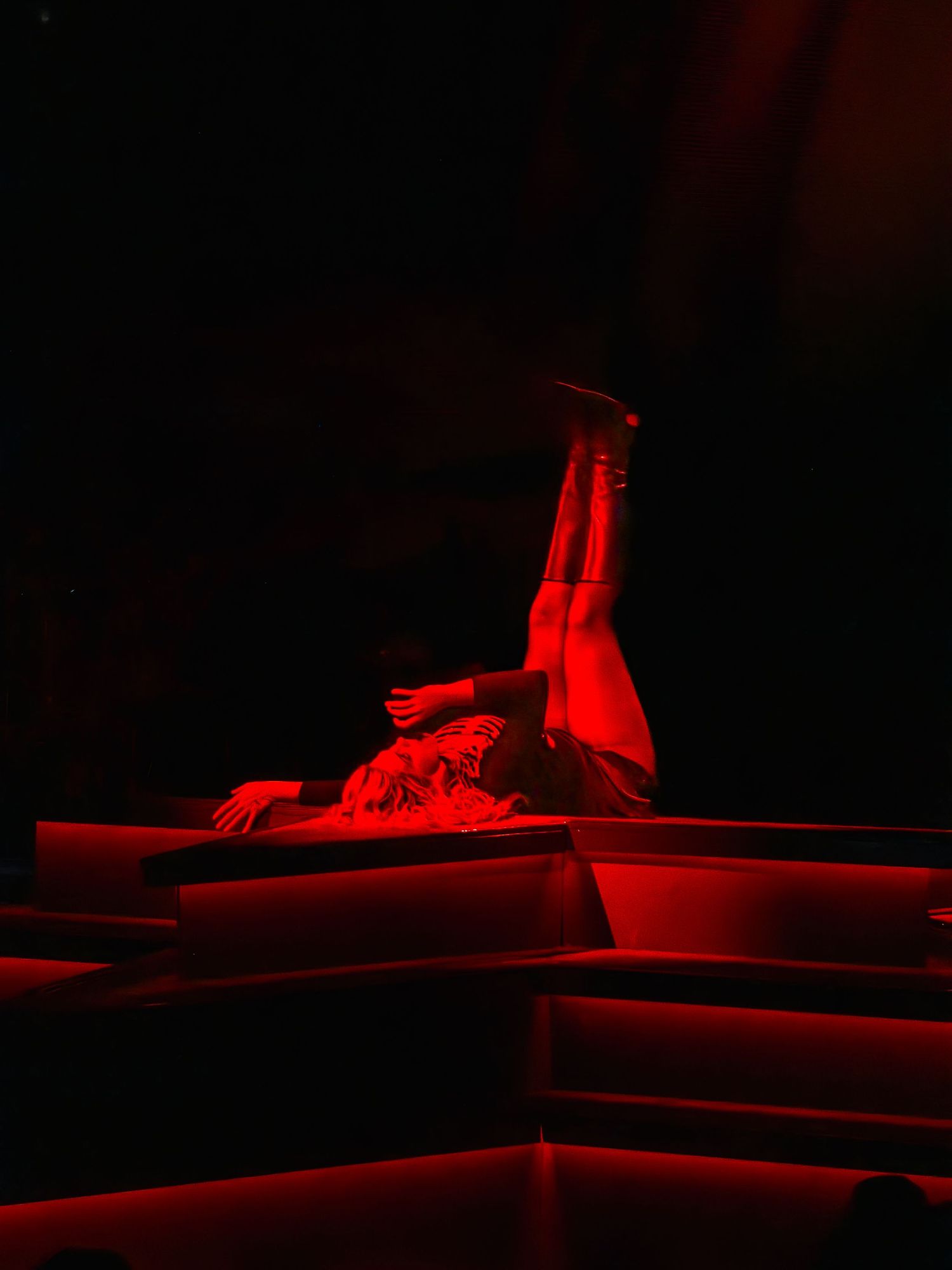 Red-lit architectural forms create dramatic geometric shapes in darkness.