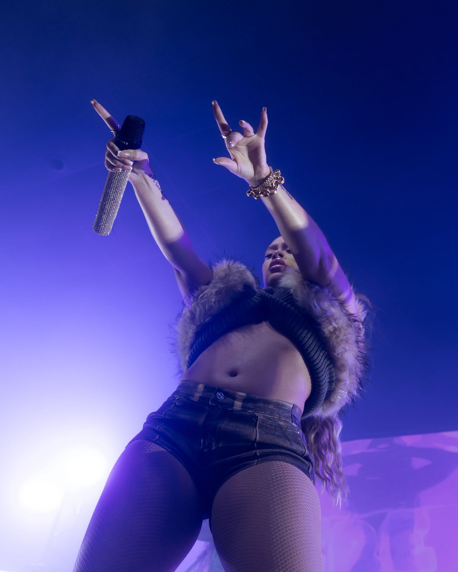 Concert performer on stage with dramatic blue lighting effects creating a dynamic silhouette.