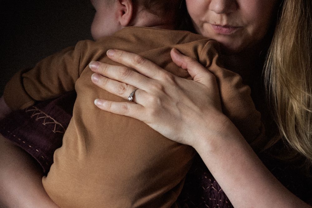 A close up image of a mother holding her baby close.