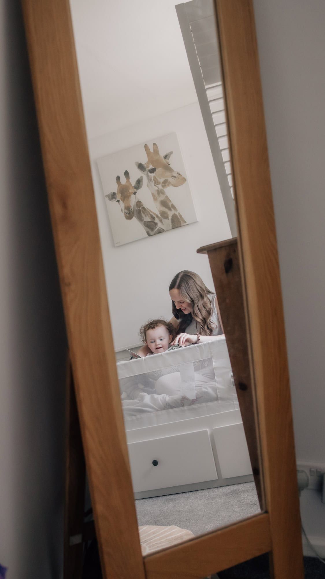 A reflection of a mother reading to her young daughter in Marlow.