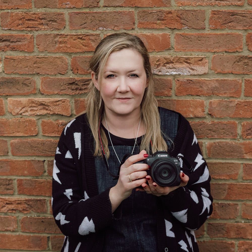 A recent head shot of Emma Challinor holding her camera.
