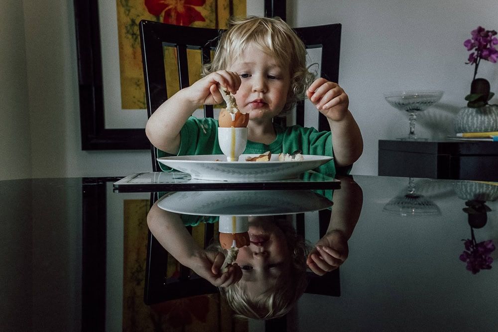 A child eats a dippy egg at home near maidenhead.