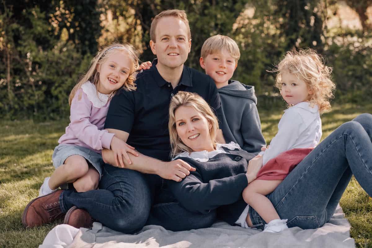 A family sitting on a picnic rug.