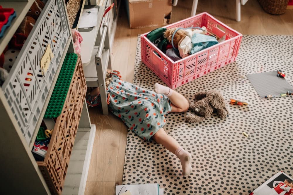 A young girl dives under a table during an in-home session in Marlow.