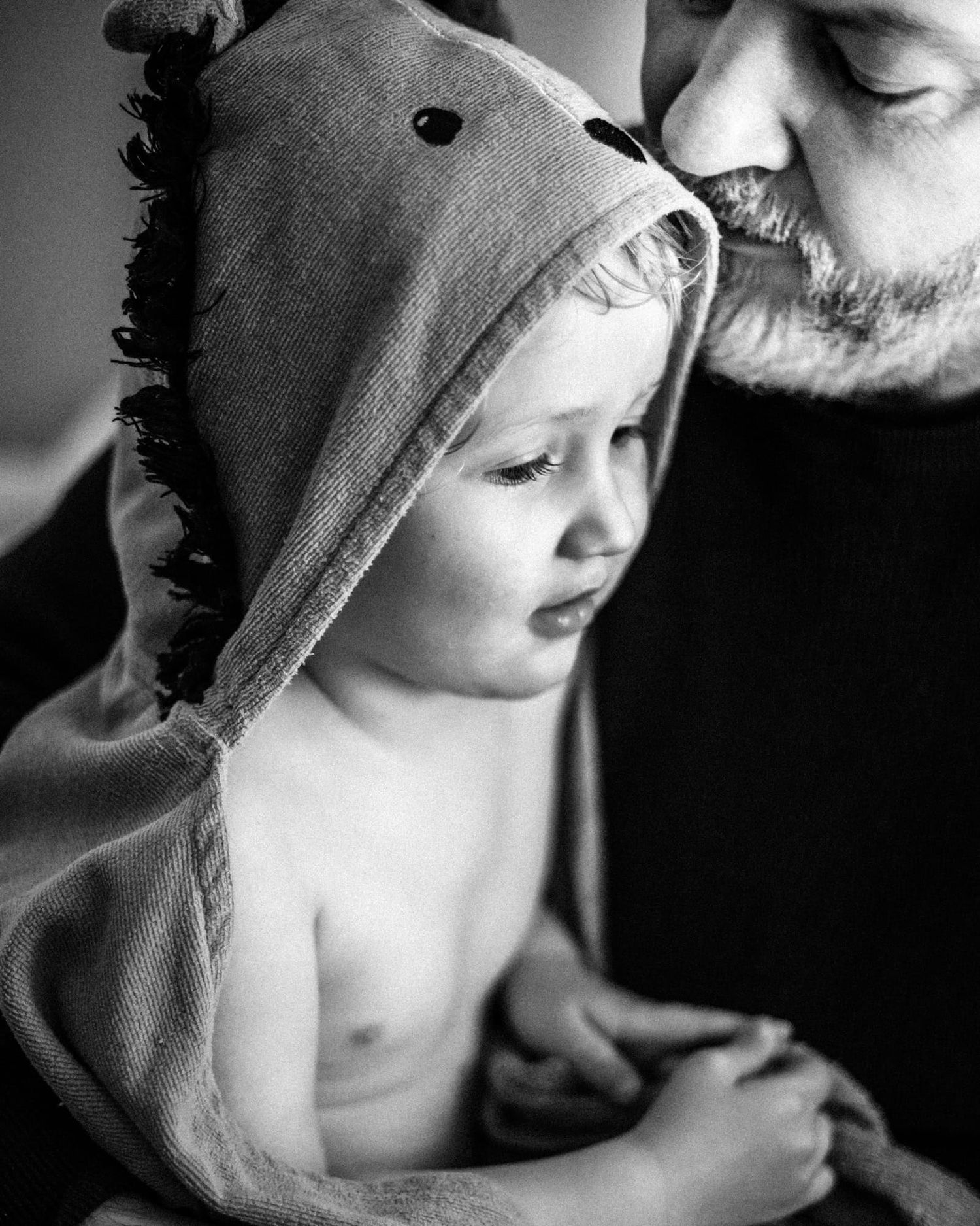 A father drying a young child after his bath.