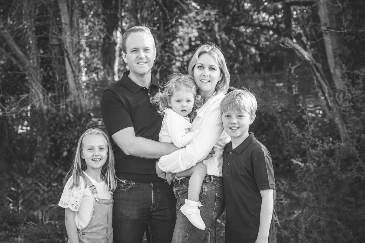 A black and white family portrait of a family of five,
