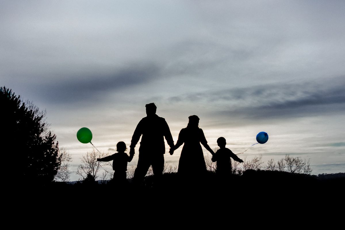 A silhouette family portrait on top of West Wycombe Hill.