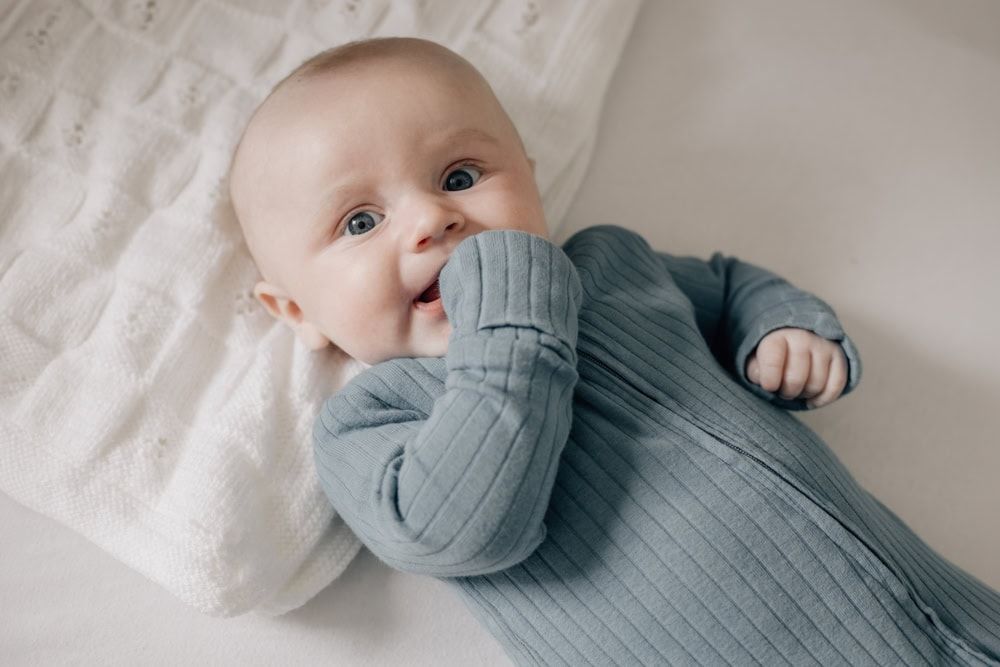 A four-month-old baby looks up at the camera during a motherhood session to document a mum's maternity leave in Marlow.