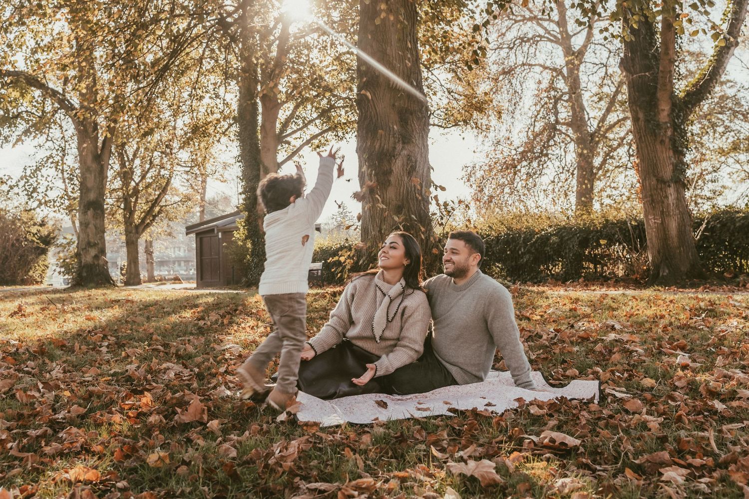 A boy throws leaves into the air on an autumn photo session.