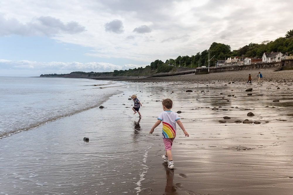 Two boys play on a beach in South Wales.