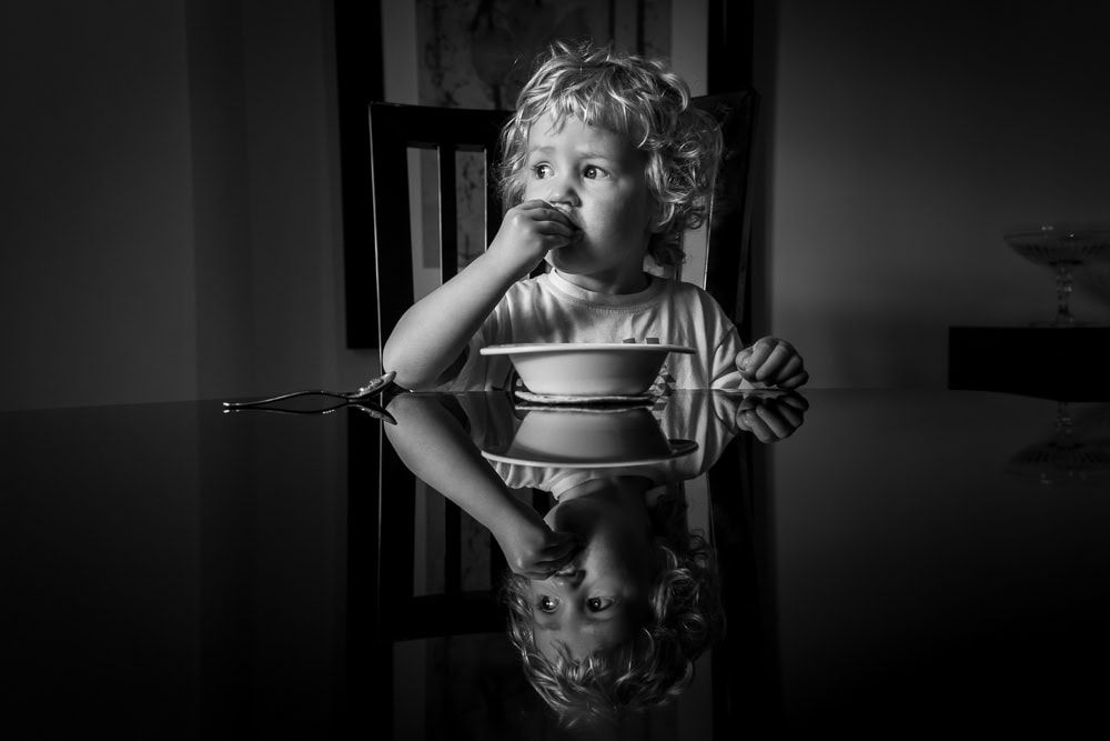 A young boy eating breakfast at his Nana's house.