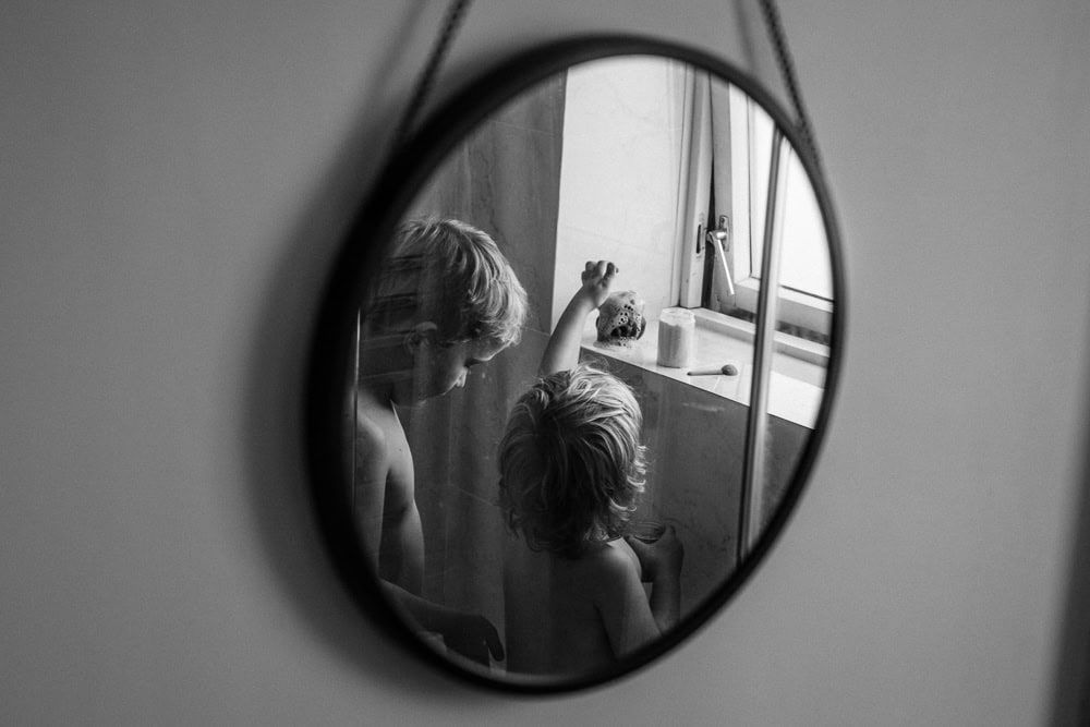 Two children make potions in a toy cauldron at bath time at home in Marlow, Buckinghamshire.