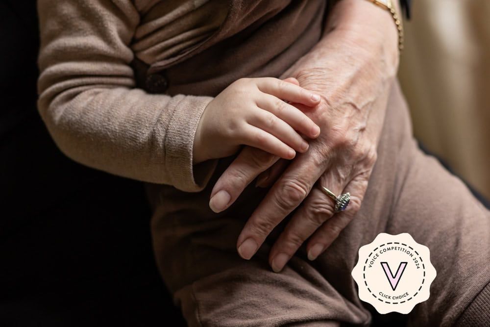 An image of a grandma holding hands with her grandson.  The image bears a stamp announcing it as Click Choice in The Voice competition.