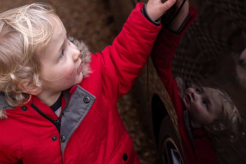 A young boy opens the car door.