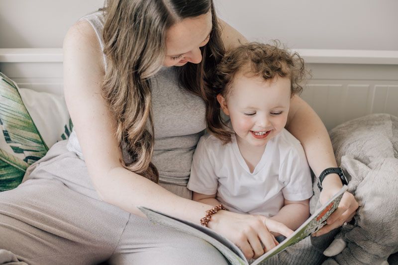 A mother reads a book to her toddler at home in Marlow during a candid photo session.
