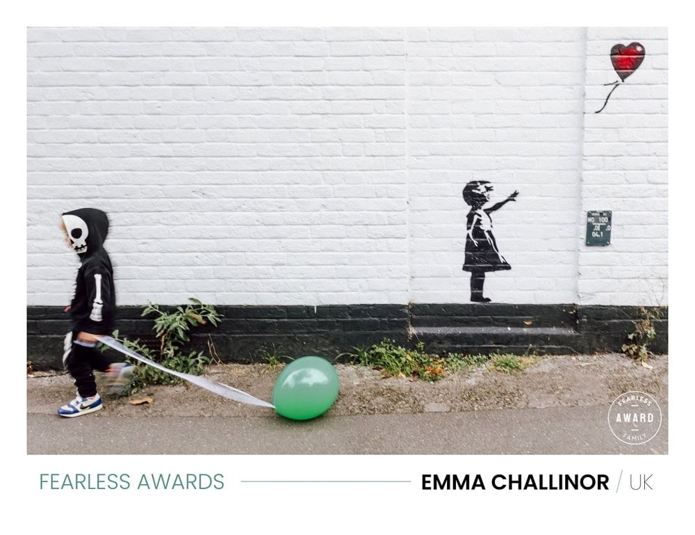 A young boy dressed as a skeleton walks passed a Banksy-inspired graffiti on Station Rise in Marlow.