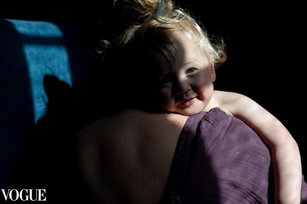 A mother holds a toddler on her shoulder.
