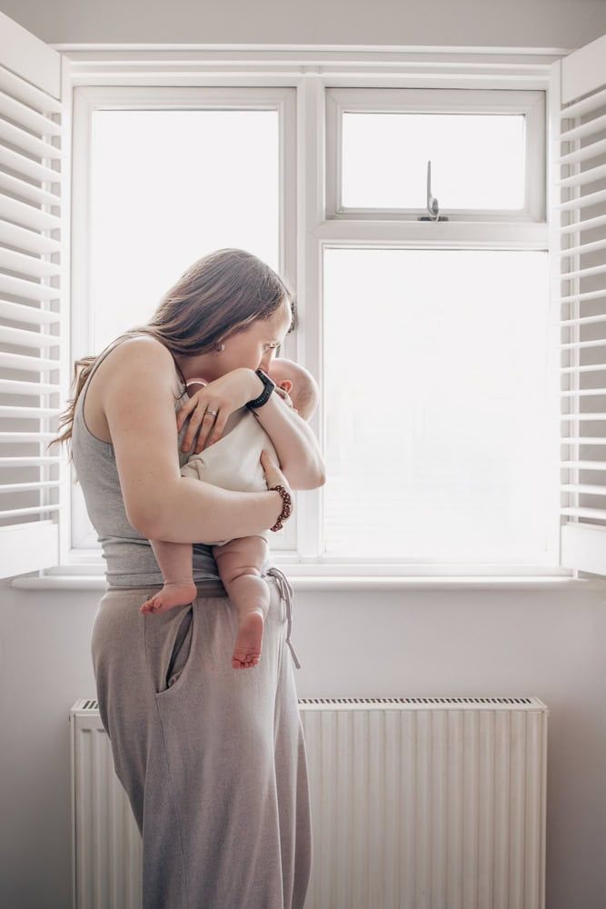 A mother rocks her baby to sleep at home in Marlow.