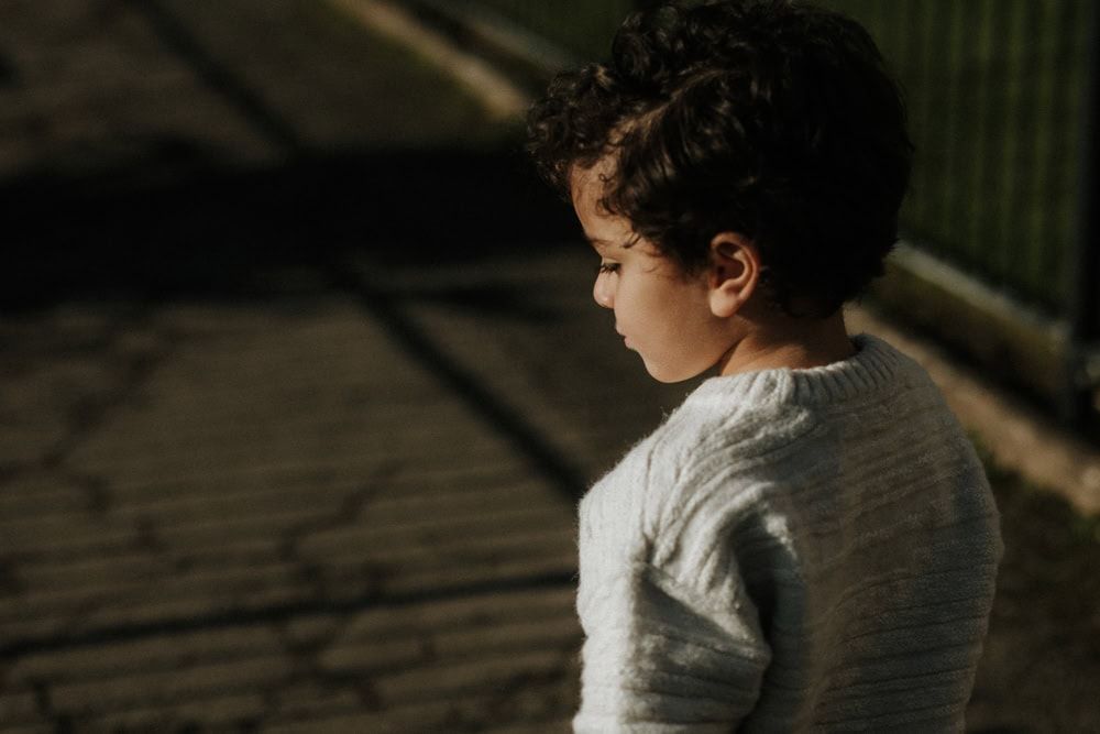 A young boy and the shadow of a gate in HIgginson Park.