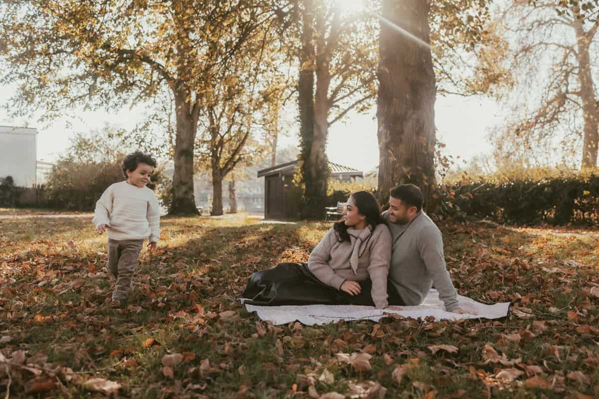 A family play games together during a relaxed family photo session in Higginson Park, Marlow.