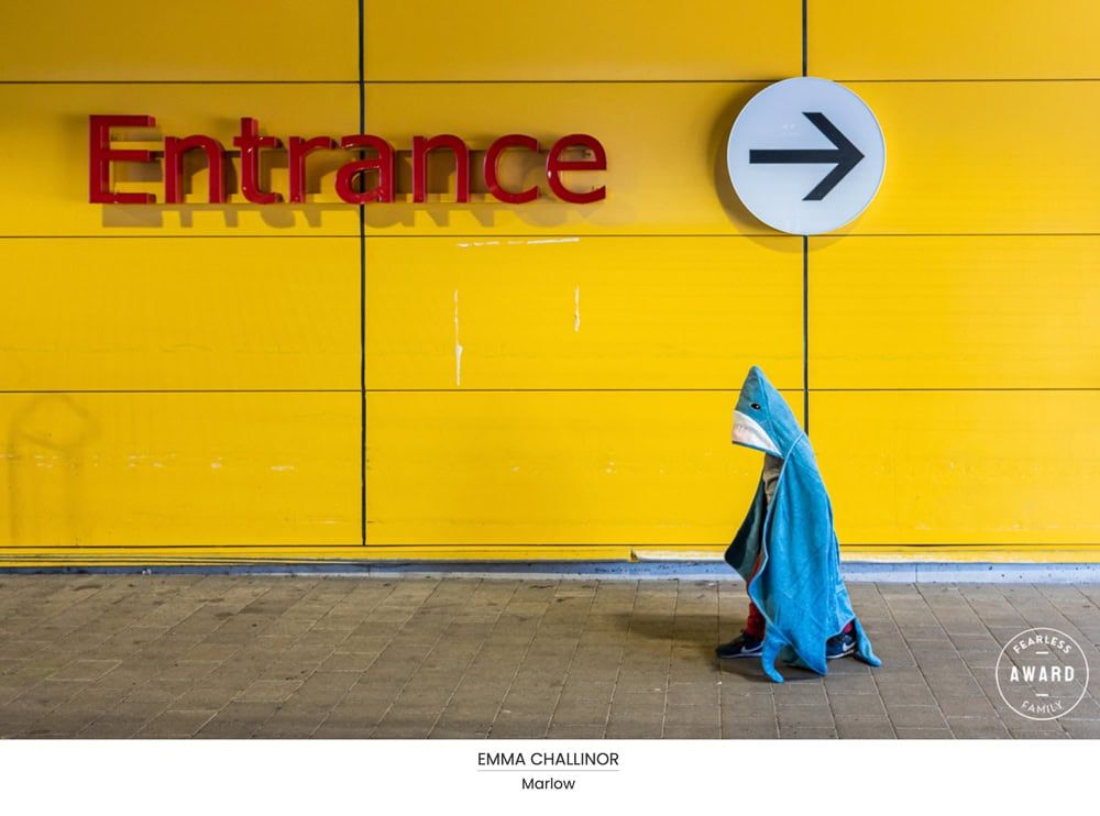 A young boy wearing a shark towel leaves Ikea.