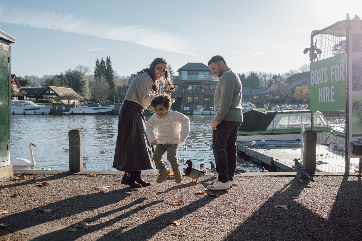 A family of three feed the ducks in Higginson Park.