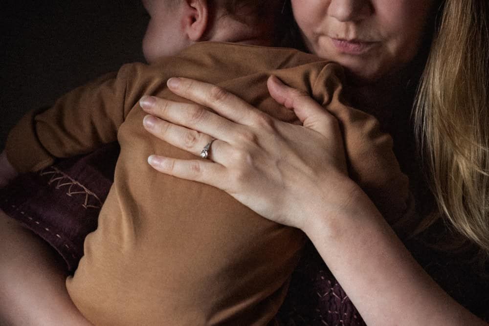 A mother holds her 3 month old baby.