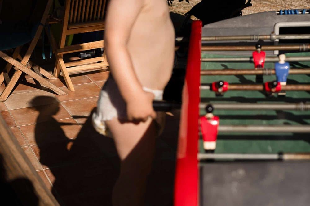 A young boy plays with a baby foot game in France.