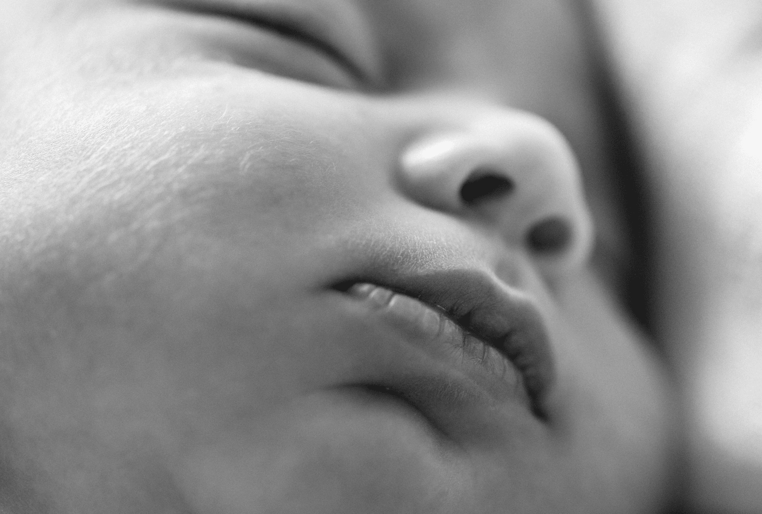 A close up image of a baby's face from a newborn photo session in Marlow.