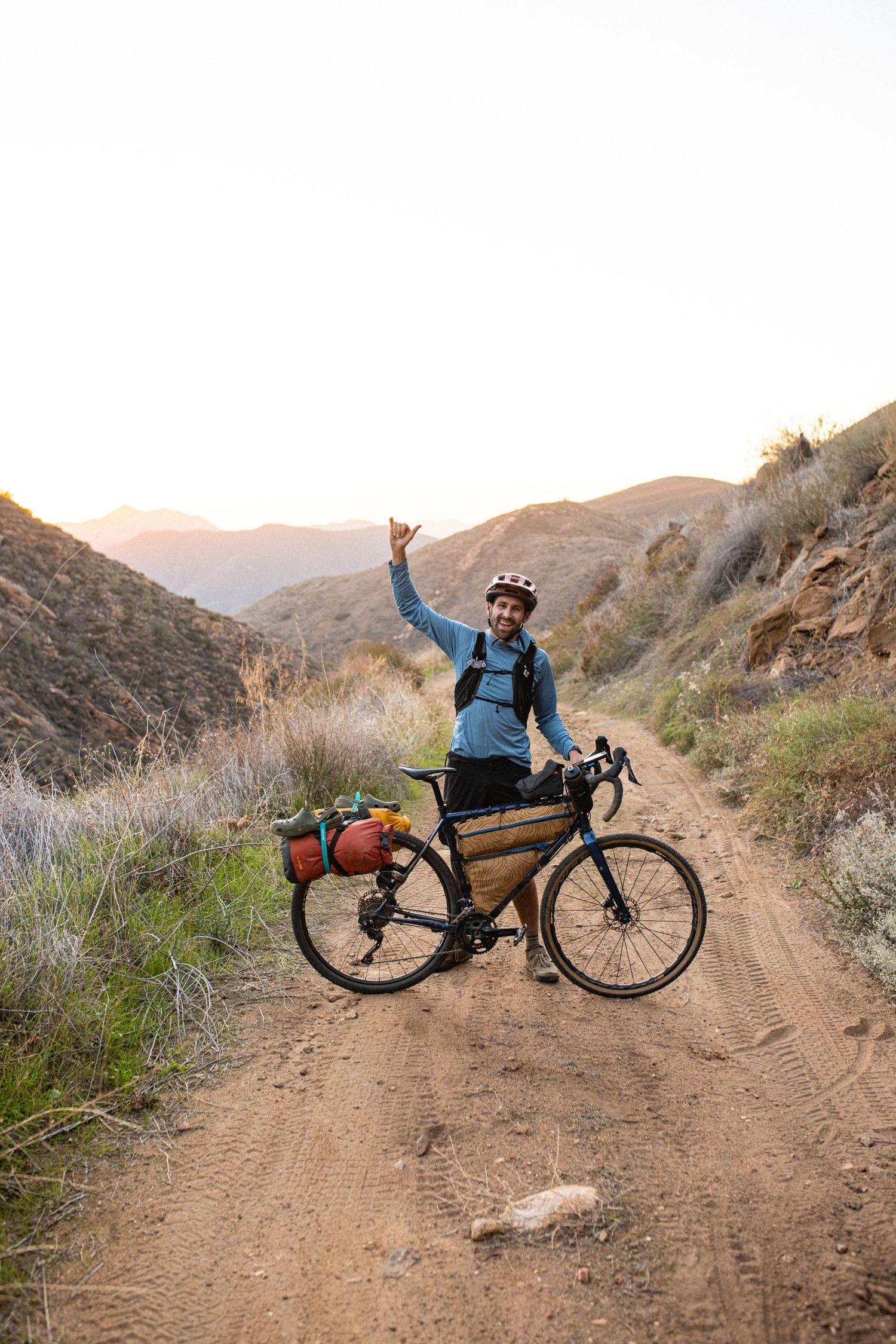 Mountain biker riding singletrack trail in desert terrain.