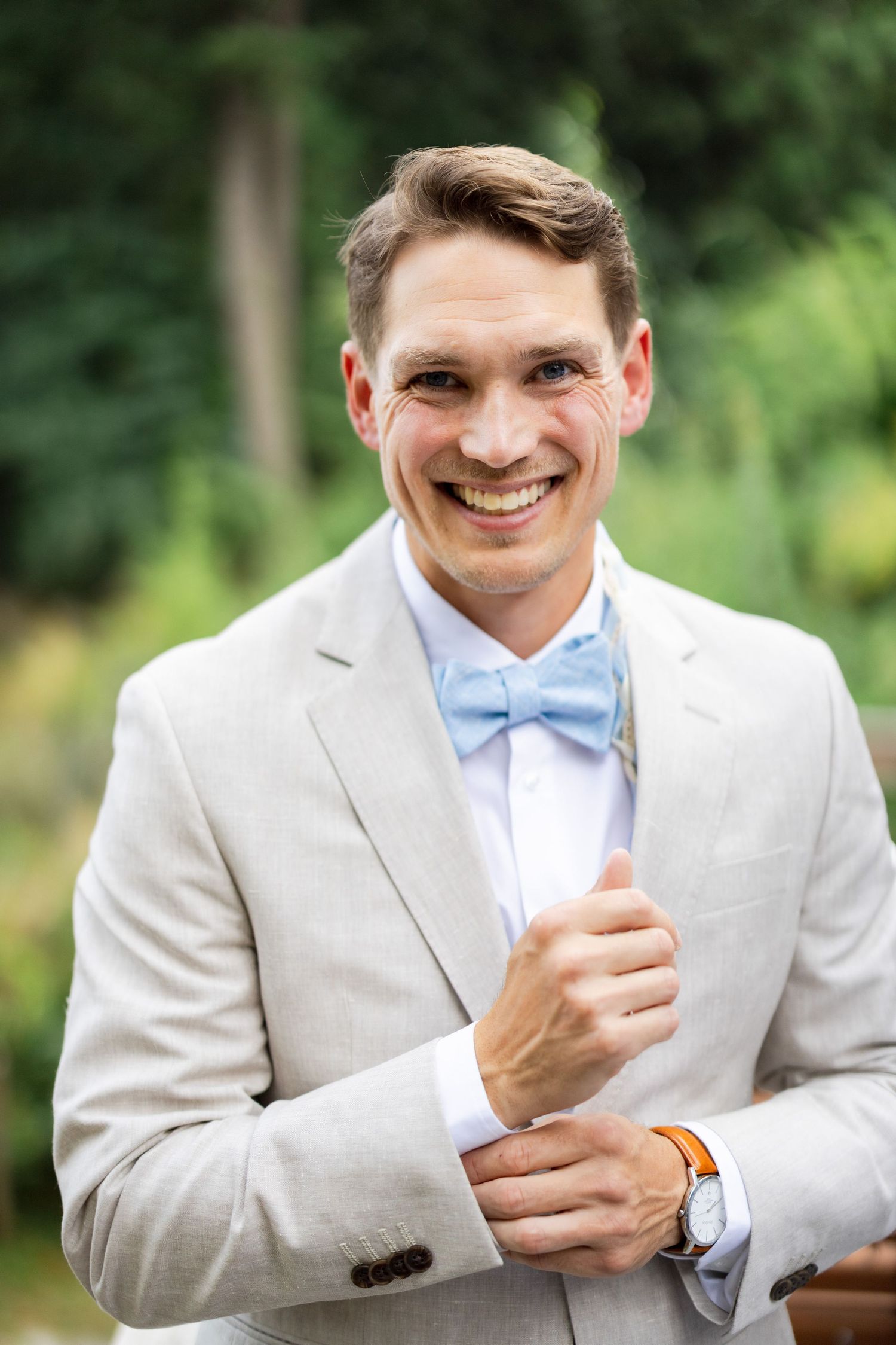 Groom portrait in light beige suit on wedding day.