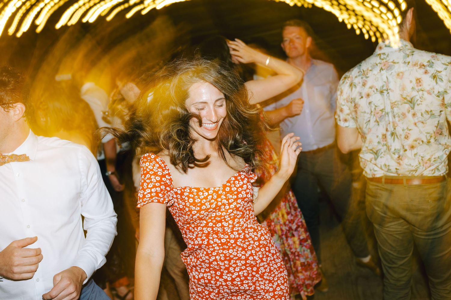 Woman in red dress, dancing at wedding.