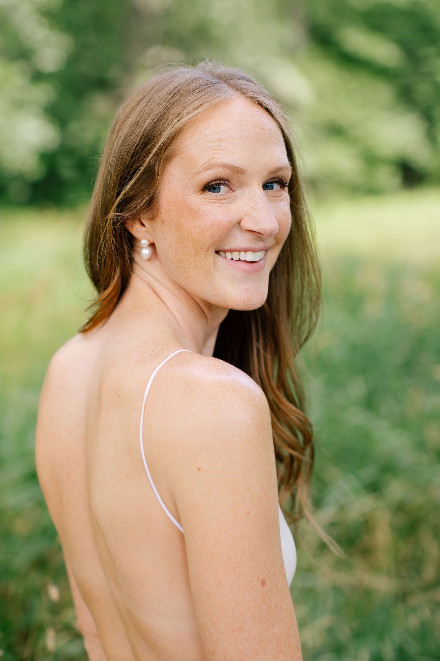 Natural light bridal portrait surrounded by greenery.