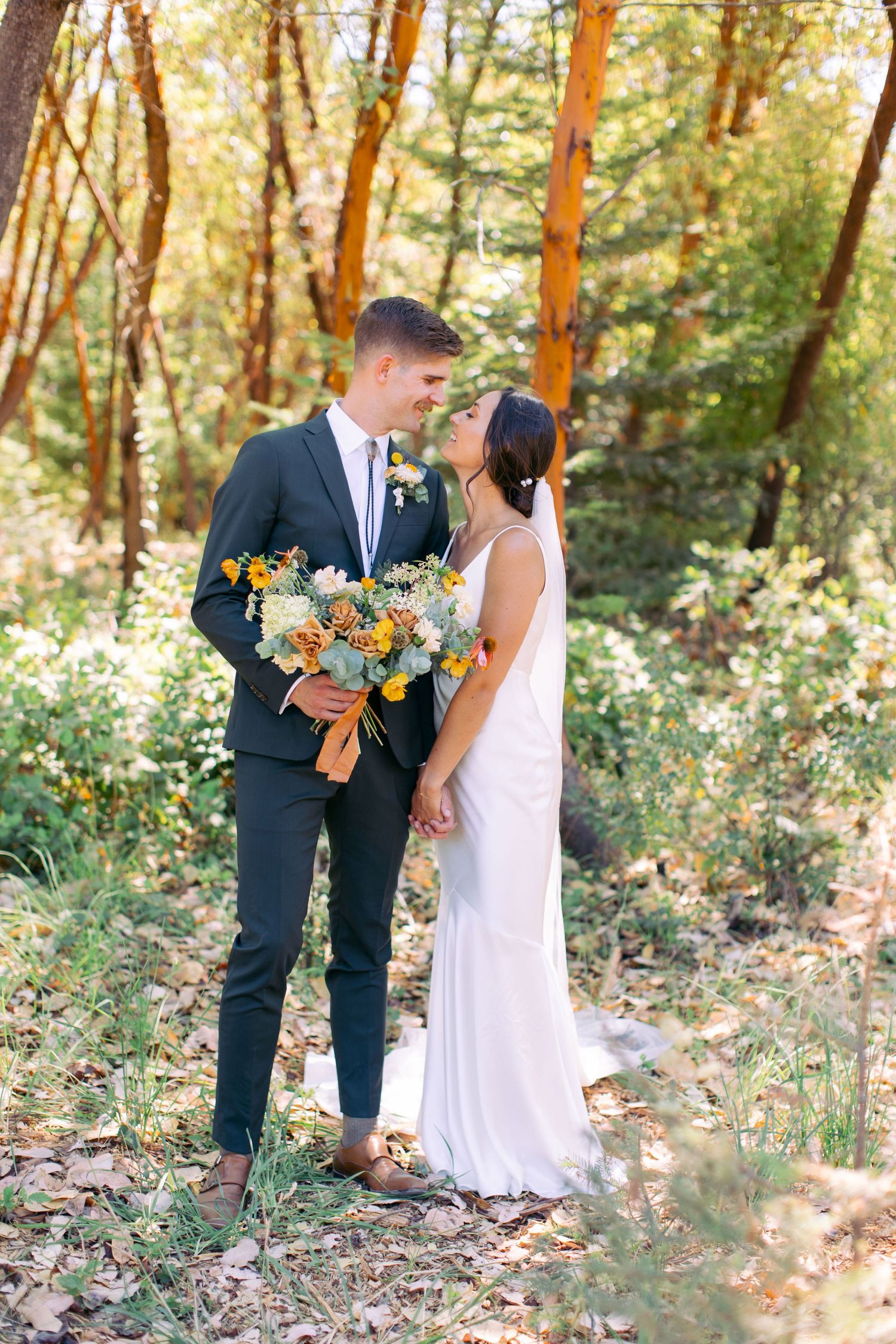Bride and groom sharing first look in forest.