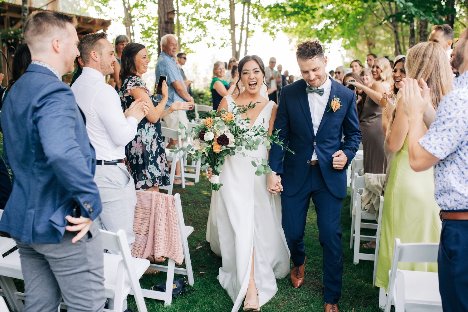 Outdoor wedding ceremony in garden setting with guests gathered.