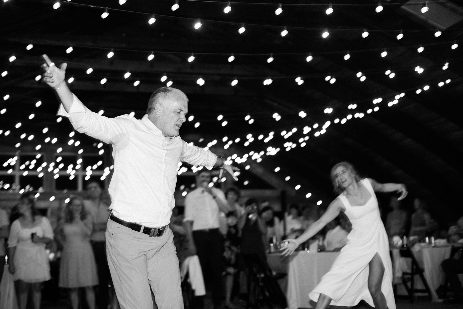 People dancing under string lights at wedding reception in Squamish.