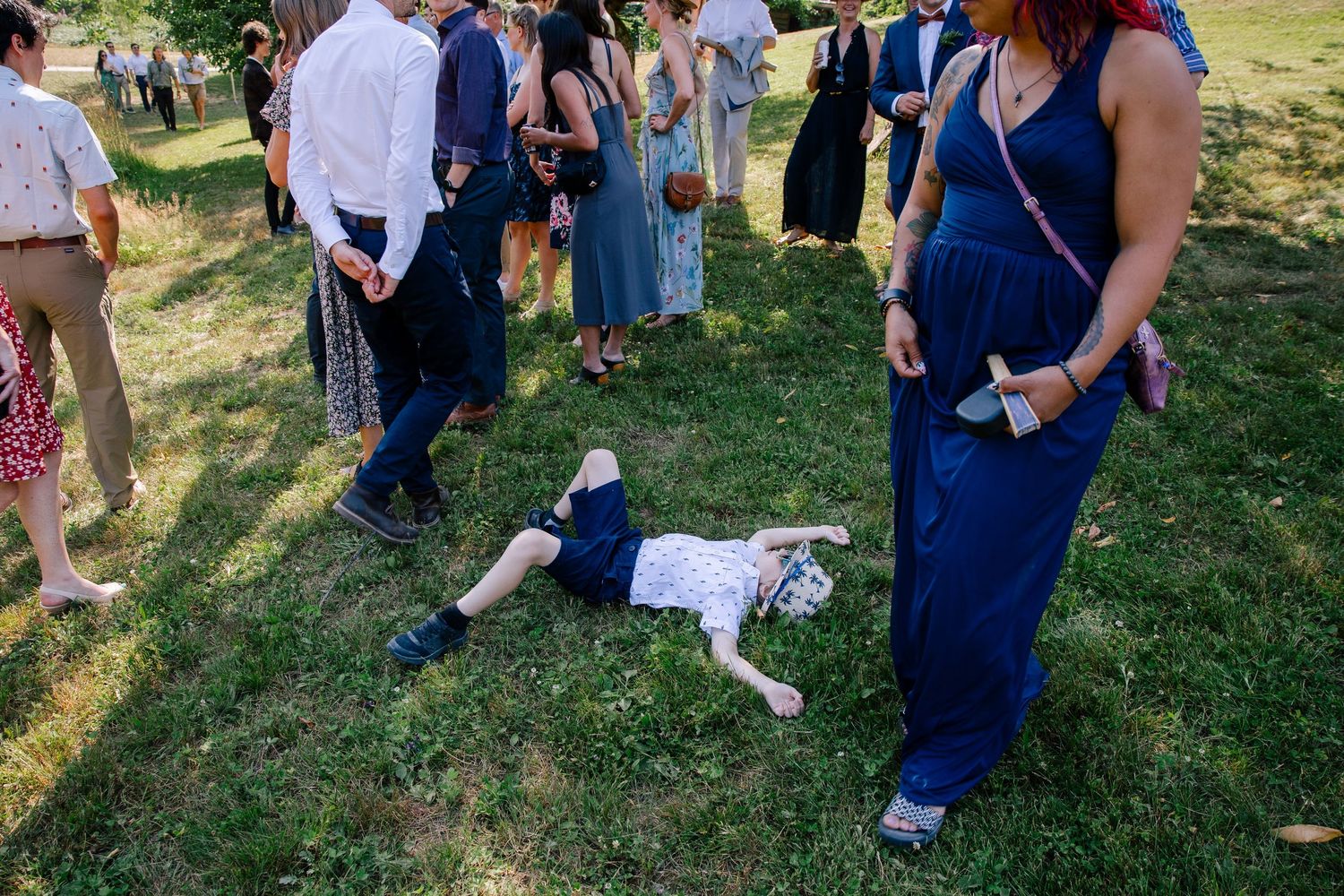 Kid laying on the grass at outdoor wedding in Squamish, BC.