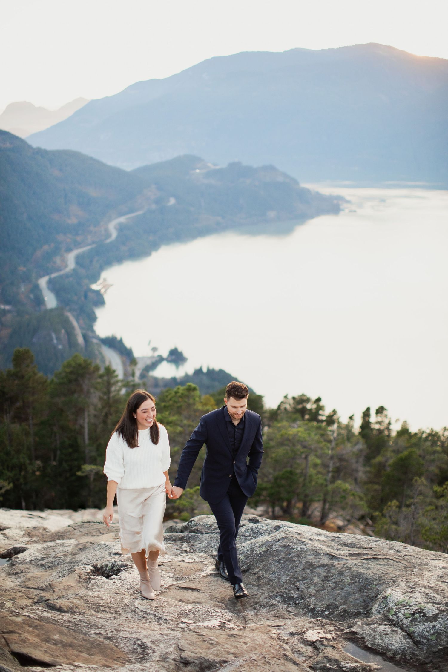 Couple walking along cliffside overlooking Howe Sound in Squamish.