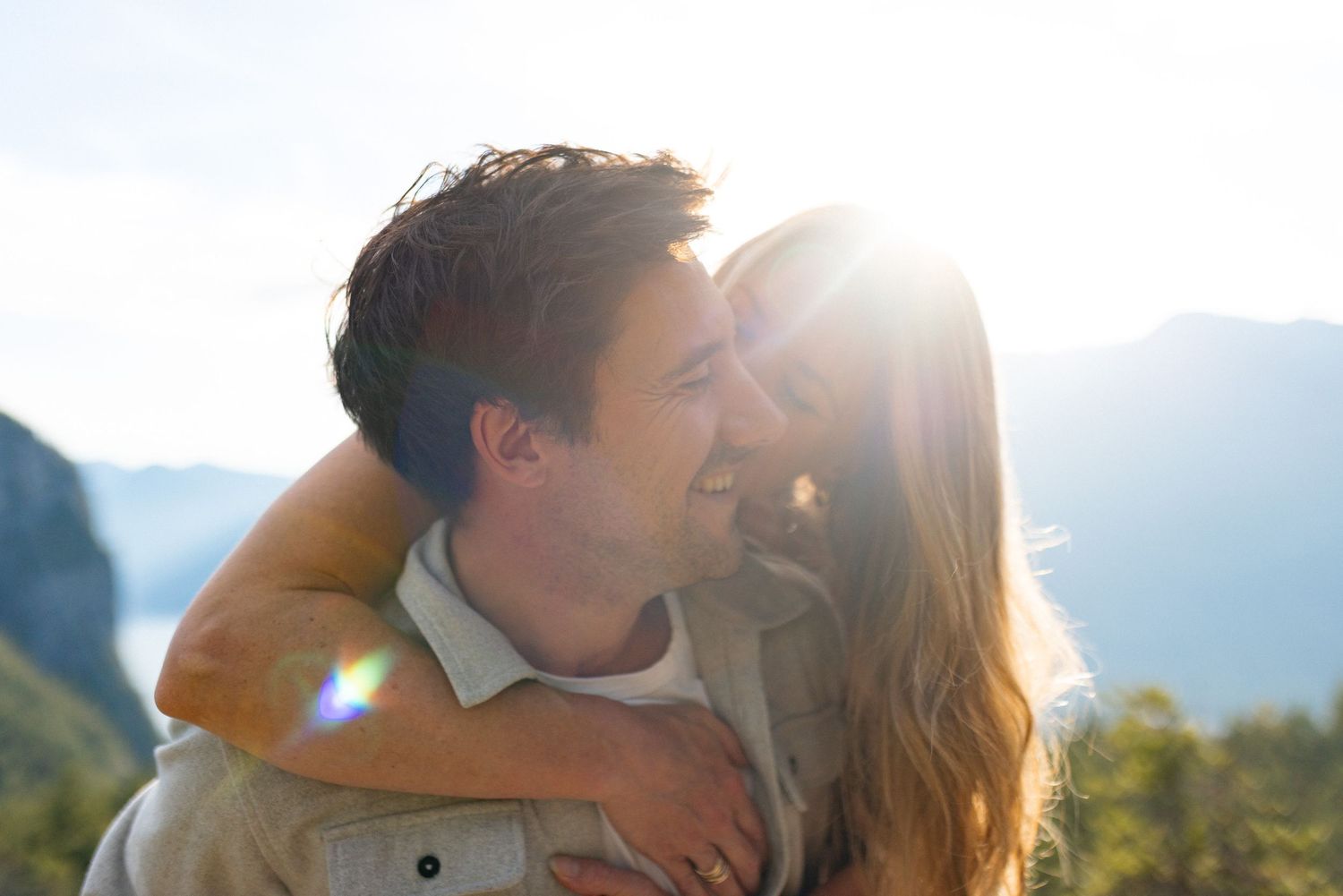 Couple embracing at sunset with golden backlight.