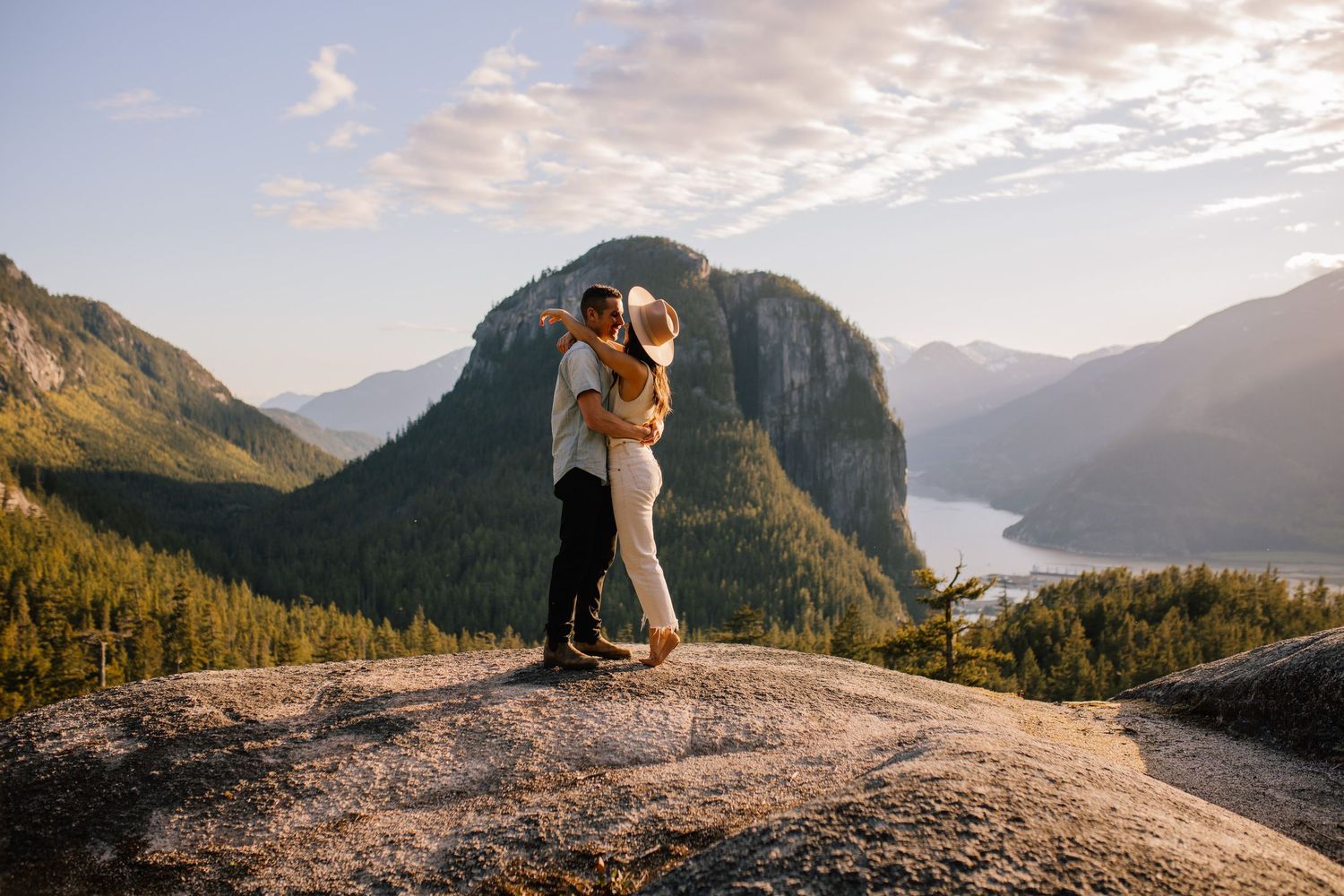 Bride and groom embracing on mountain overlook in Squamish at golden hour.