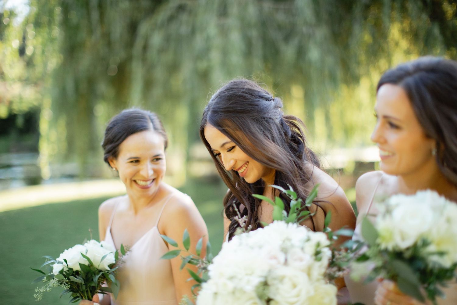 Bridesmaids laughing together in natural light.