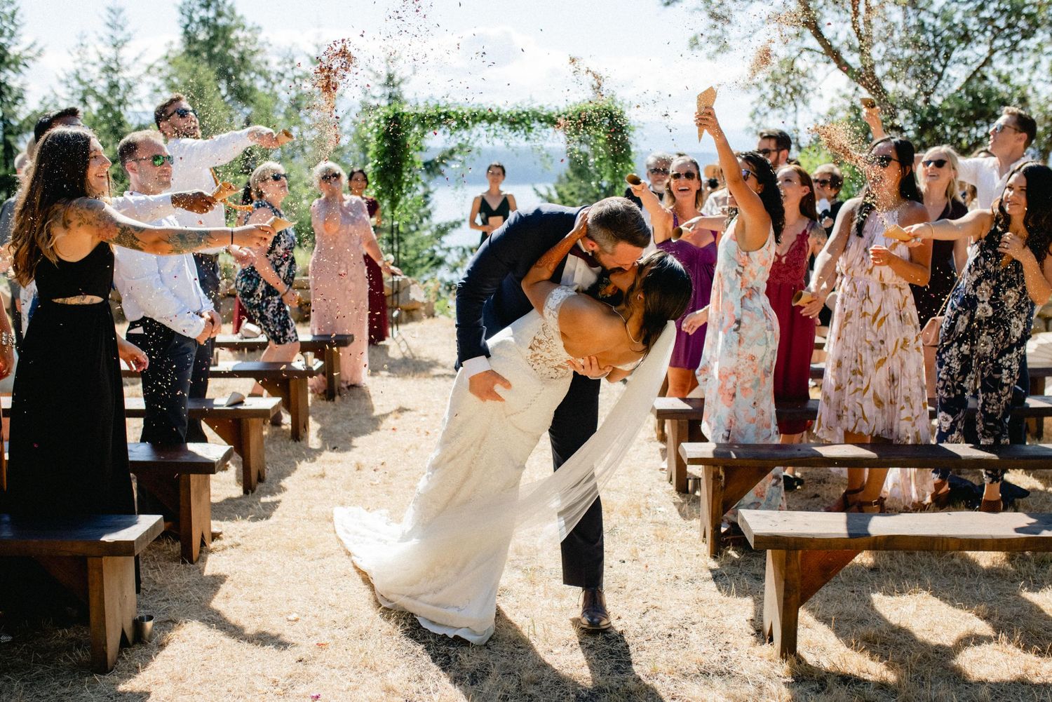 Wedding ceremony moment with guests cheering.