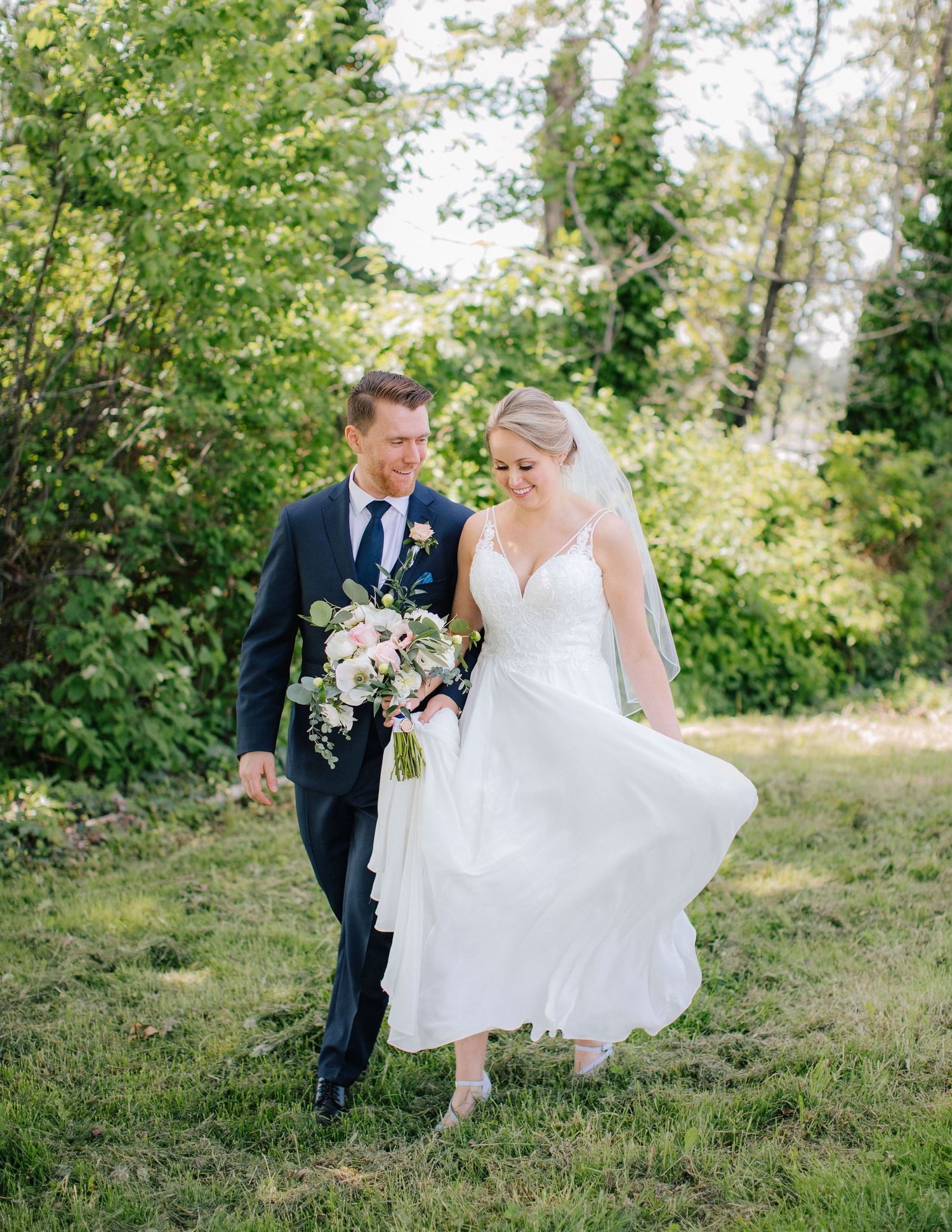Bride and groom walking through forest trail in Squamish after their outdoor wedding ceremony.