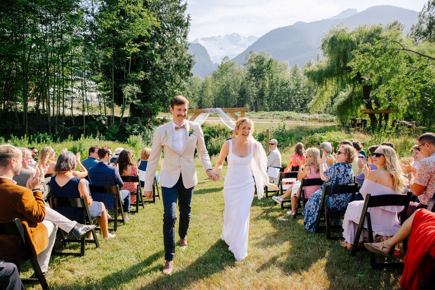 Just married couple in front of mountain backdrop at outdoor wedding in Squamish.