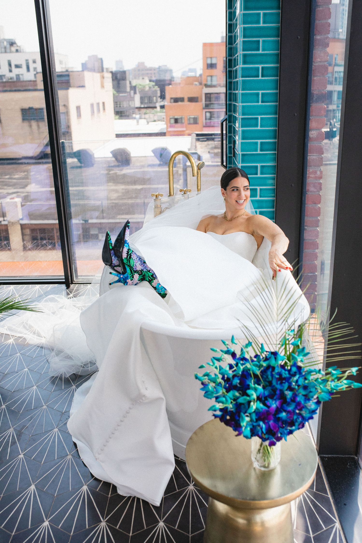 Bride holding bouquet near window light in downtown setting.