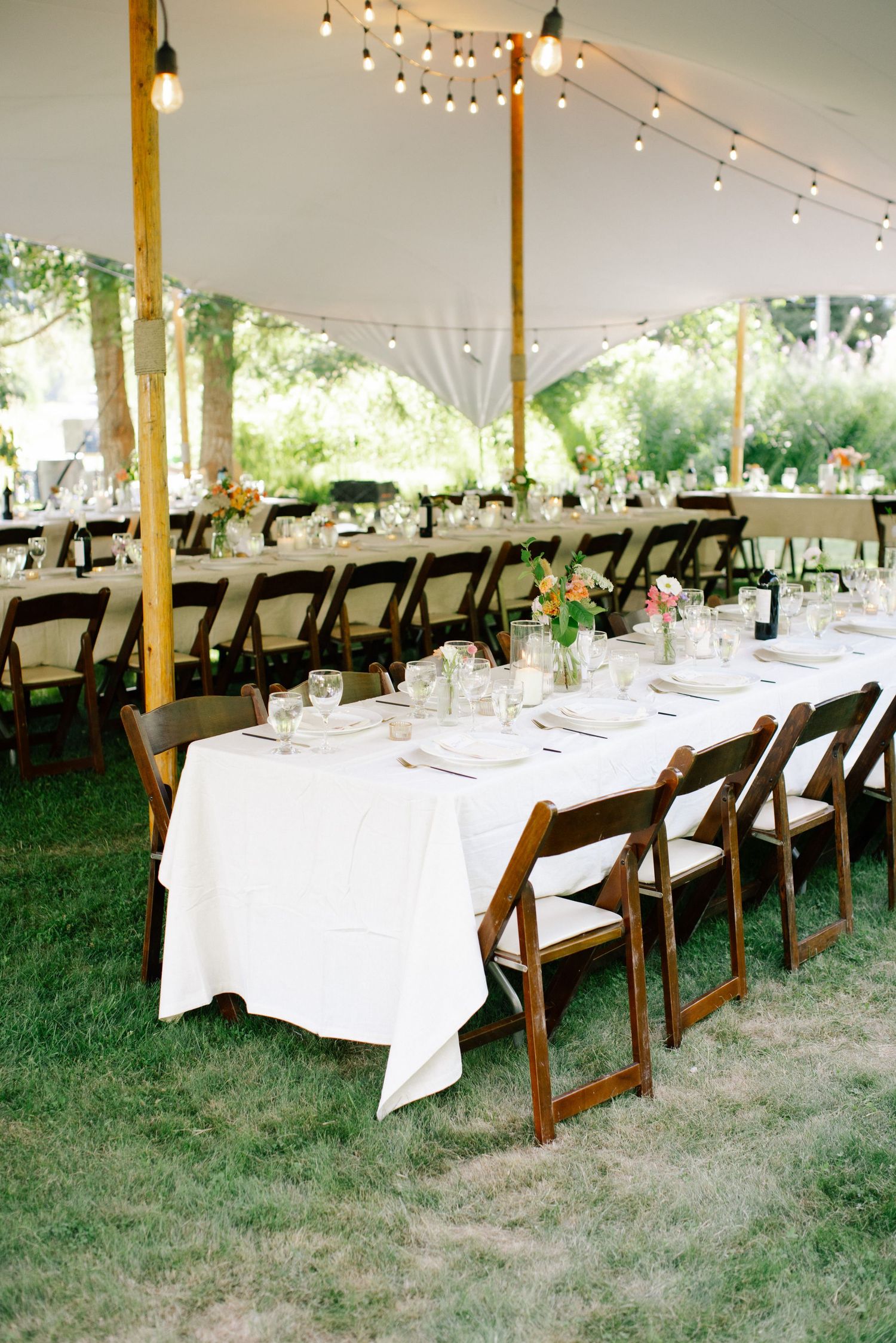 Long wooden reception table styled for outdoor wedding reception in British Columbia.