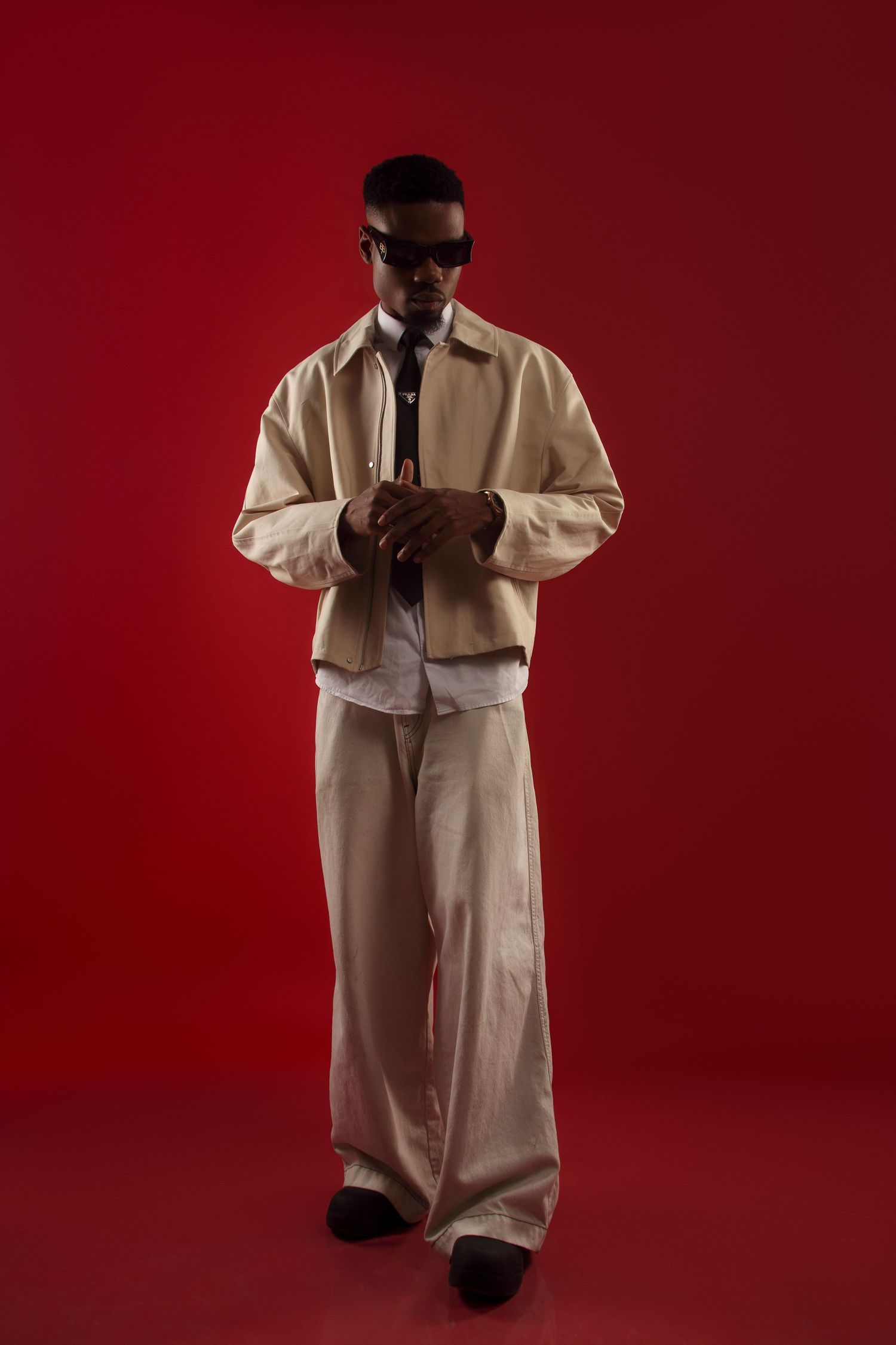 Artistic portrait series with person in cream colored clothing on red background.