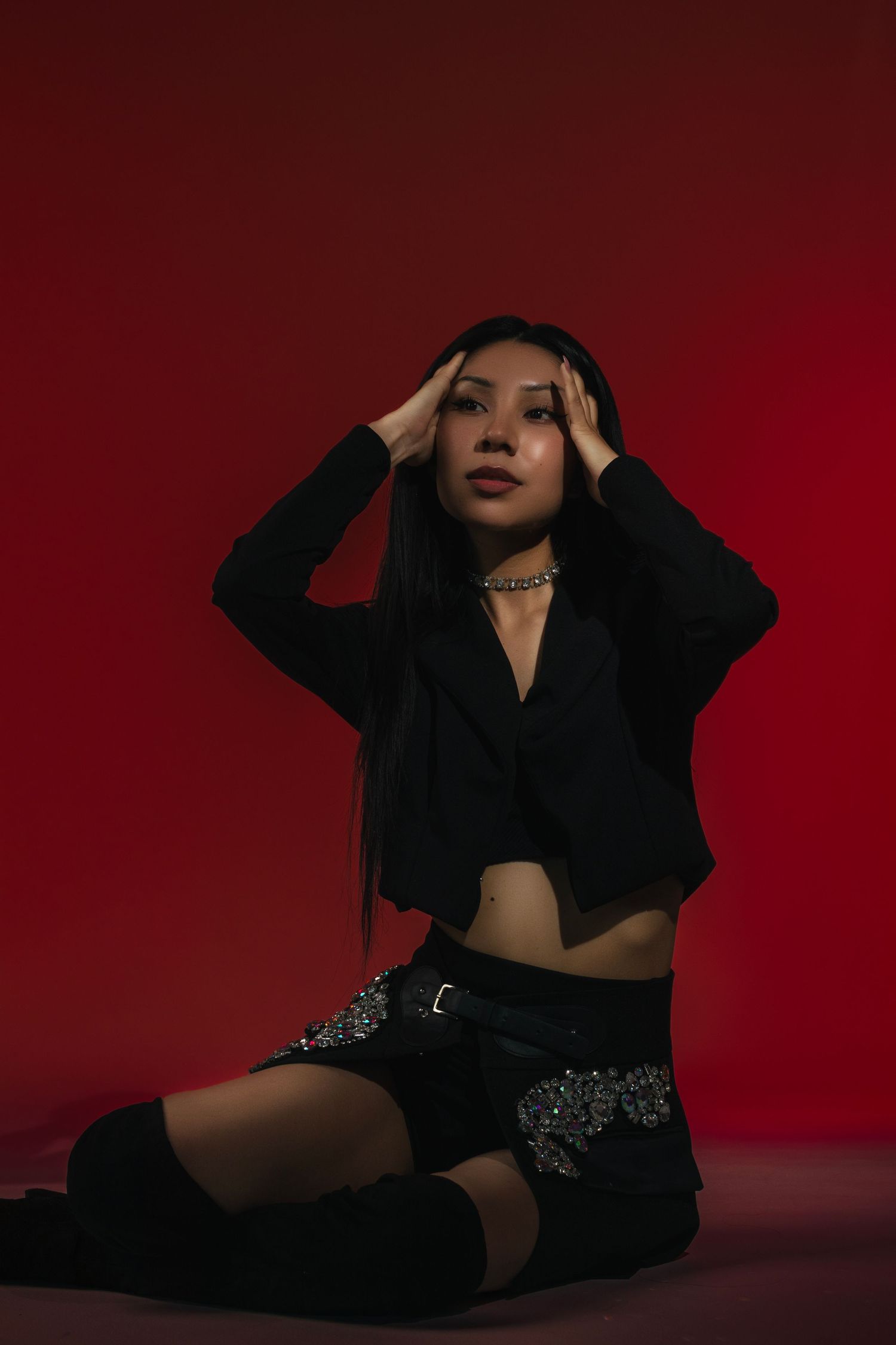 Fashion portrait series against a deep red background featuring dramatic poses in black clothing.