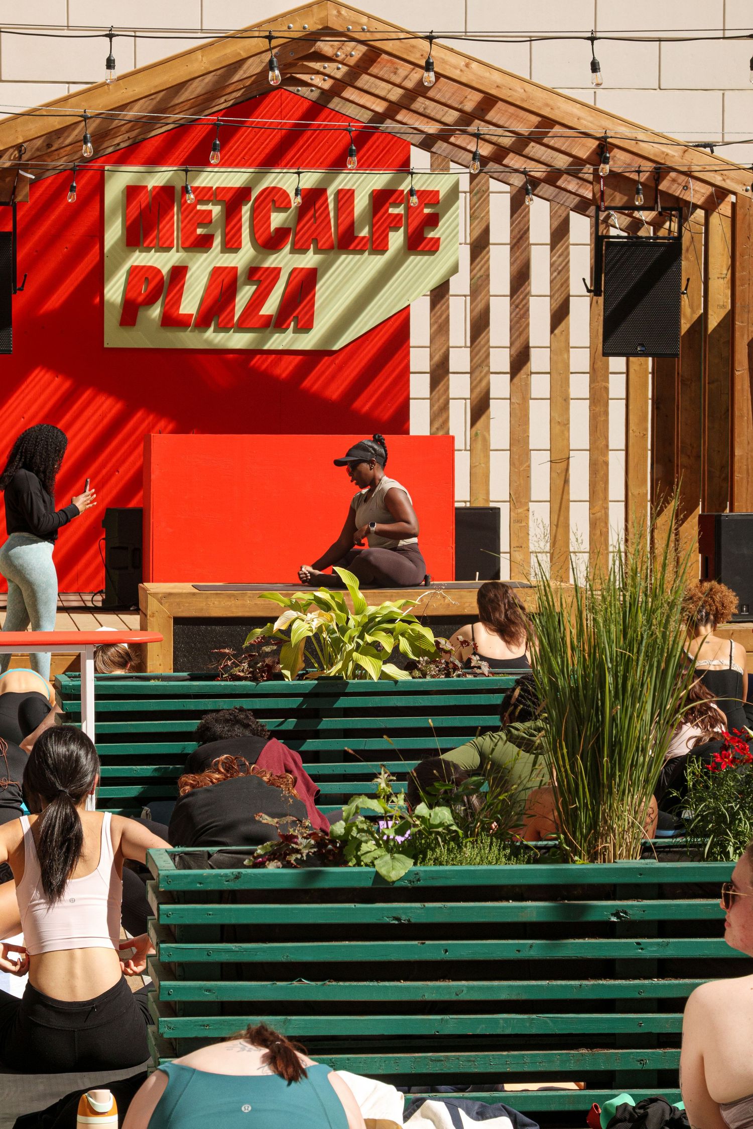 Red awning and green benches create vibrant outdoor seating area.